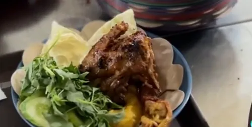 Ayam panggang, lalapan, dan sate disajikan di piring beralas kertas